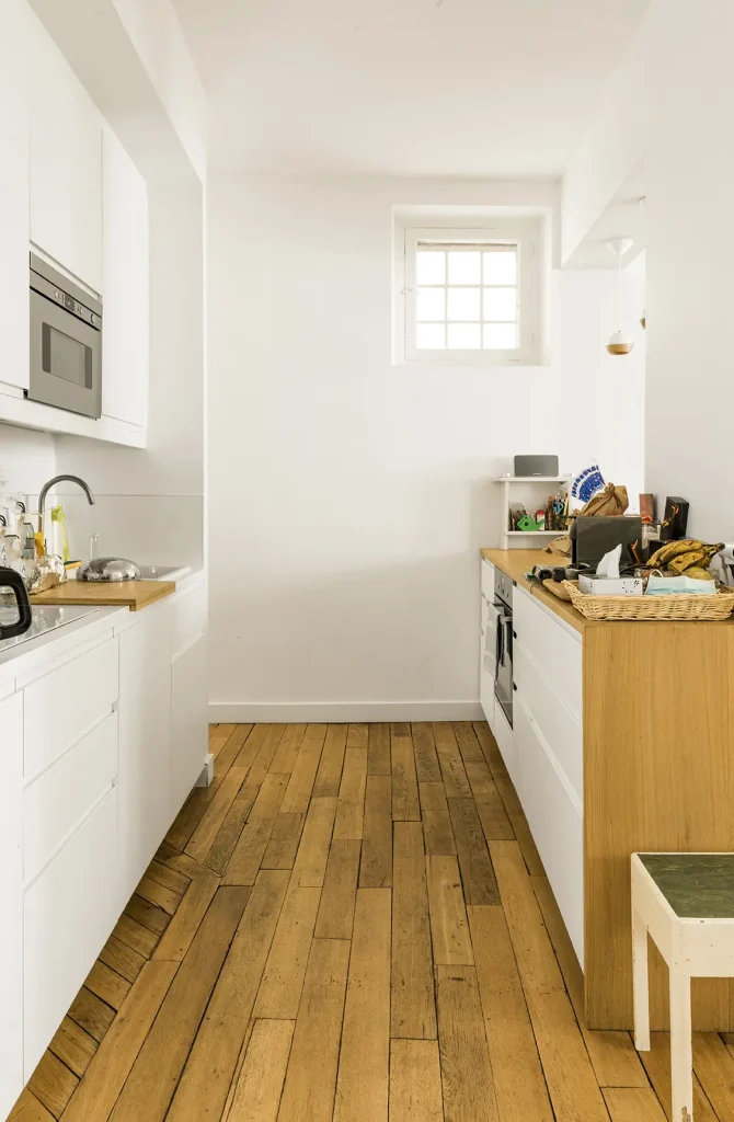 Cuisine d'un appartement rénové par VDI, couleur blanche et matière bois